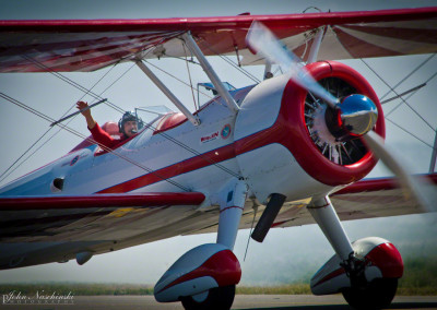 Gary Rower Waiving to Crowd in His Stearman