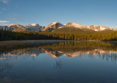 Panoramic photograph of Bierstadt Lake Mountain reflecting though the water and grasses growing on the shoreline