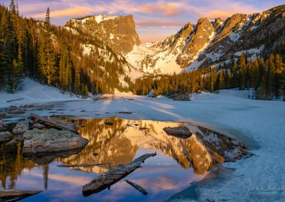 Partially Frozen Dream Lake Reflecting Hallett Peak with Colorful Sunrise Bow Clouds