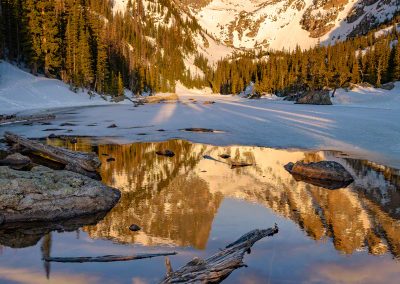 Photo of Partially Frozen Dream Lake Reflecting Hallett Peak with Dramatic Bow Clouds