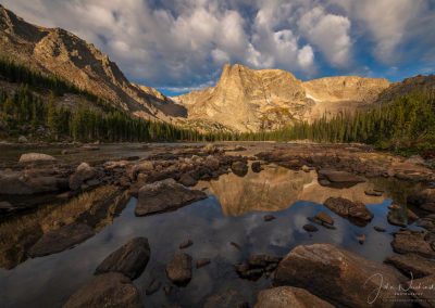 Photo of Dramatic Light and White Puffy Clouds Over Notchtop Mountain and Two Rivers Lake Rocky Mountain National Park