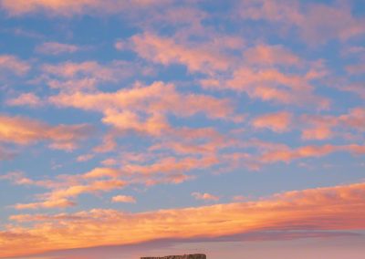Vertical Photo of Brilliant Blue Skies with Orange and Pink Clouds over Castle Rock at Dawn