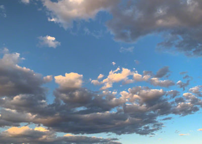 Vertical Photo of The Rock with Dramatic White High Clouds Above