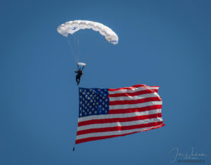 US Air Force Wings of Blue Parachute Demonstration Team Member Unfurling Old Glory During National Anthem