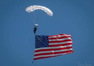 US Air Force Wings of Blue Parachute Demonstration Team Member Unfurling Old Glory During National Anthem