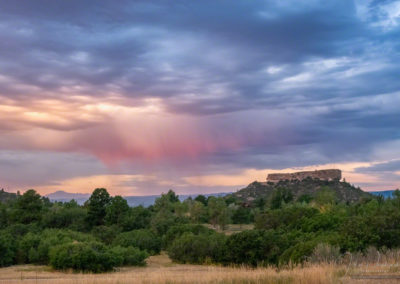 Shafts of Pink Colored Virga at Sunrise over Castle Rock Colorado with Pikes Peak