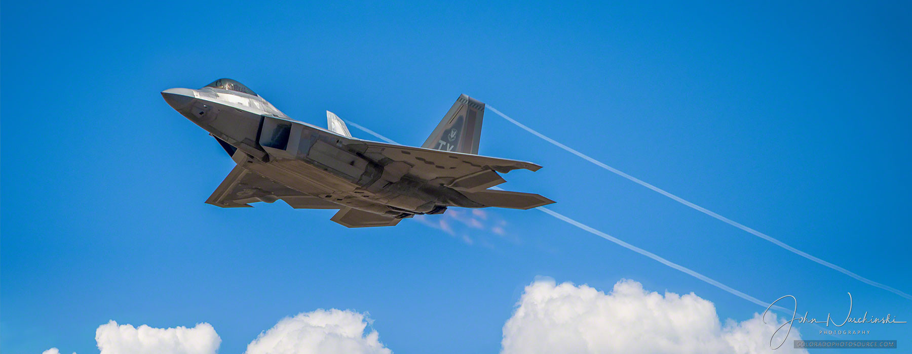 Photo of USAF F-22 Raptor in Flight with Vapor Trails