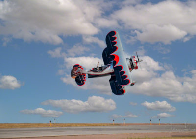 Kyle Franklin in Dracula Biplane flying low to ground one handed at Pikes Peak Regional Airshow
