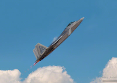 Vapors and After Burners on F-22 Raptor Stealth Fighter in Clouds