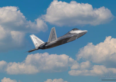 Photo of F-22 Raptor Stealth Fighter Climbing into Clouds