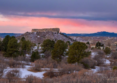 Snow and Dramatic Pink Magenta Clouds behind Illuminated Castle Rock Star at Dawn