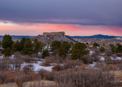 Snow and Strip of Pink Magenta Clouds behind Illuminated Castle Rock Star at Dawn