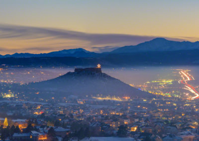 Stunning Panoramic Photo of Illuminated Castle Rock Star and Pikes Peak Above the Valley Haze and Fog
