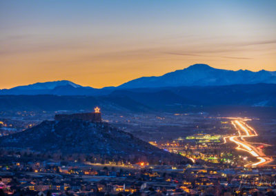 Stunning Blue Hour Photo of Illuminated Castle Rock Star and Pikes Peak with Cars on I-25