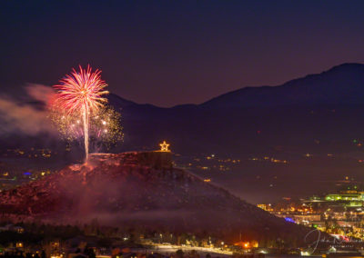 Night Sky Glows with Fireworks over the Rock in Castle Rock Colorado with Pikes Peak in Background at the Annual Starlighting Ceremony