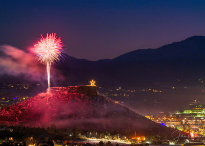 Beautiful Glowing Night Sky with Fireworks over the Rock in Castle Rock Colorado with Pikes Peak in Background at the Annual Starlighting Ceremony